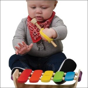 Baby using the EazyHold Universal Cuffs as an adaptation to build hand skills for play