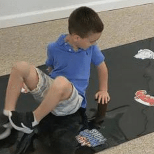 My Motor Mats movement path, boy completing a crab walk on a black motor mat